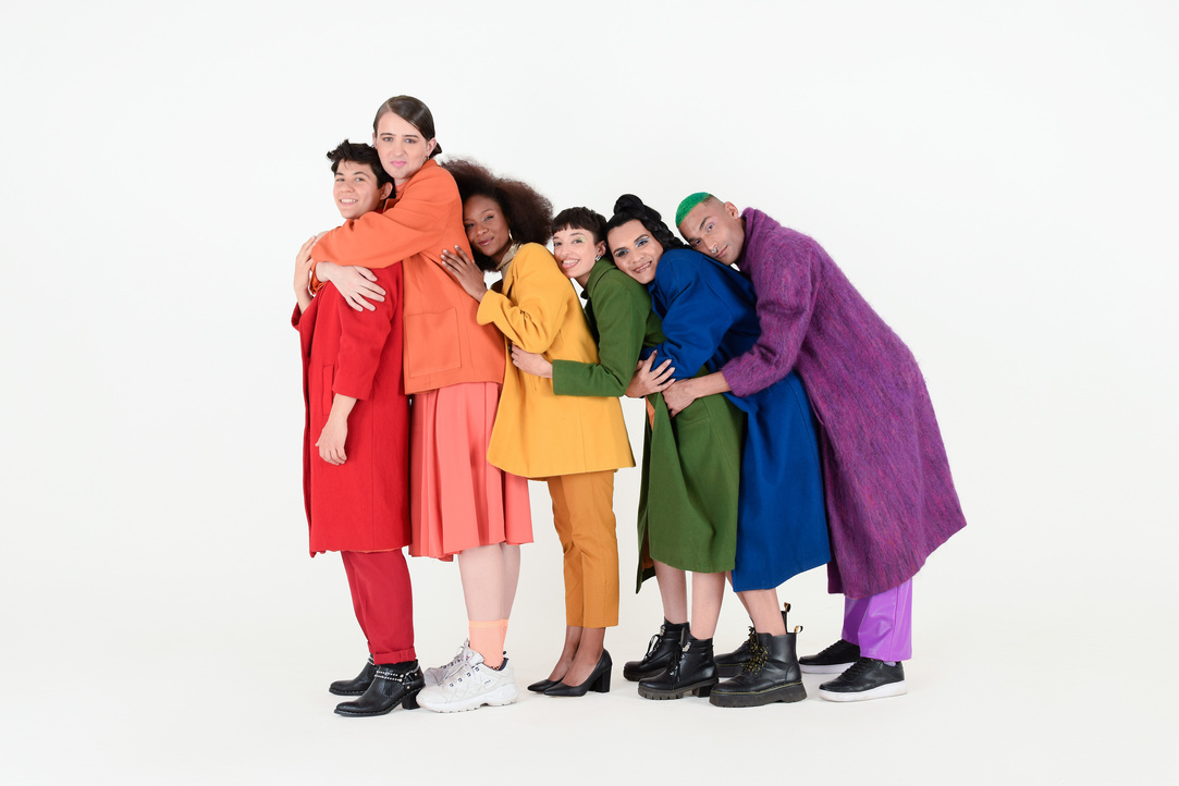 Non-Binary Friends in Colorful Outfits on White Background